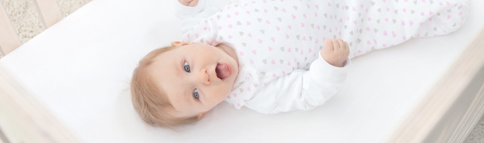 Baby liegt auf einer Matratze.