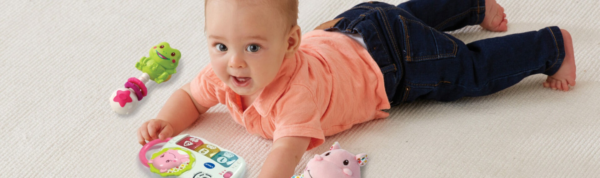 Auf dem Bauch liegendes Baby mit Produkten aus dem VTech Babys Geschenkset