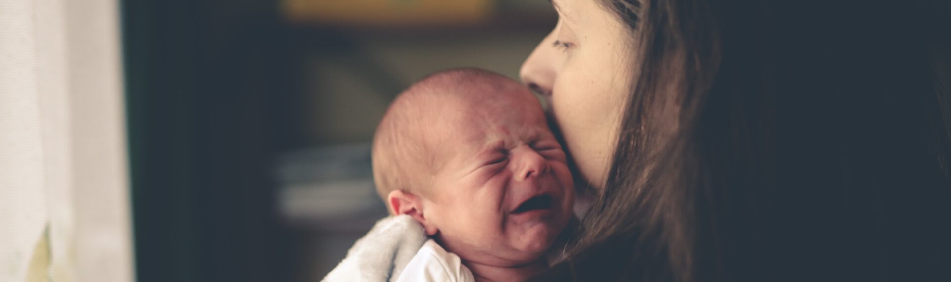 Baby in den Armen der Eltern, das sanft beruhigt wird.